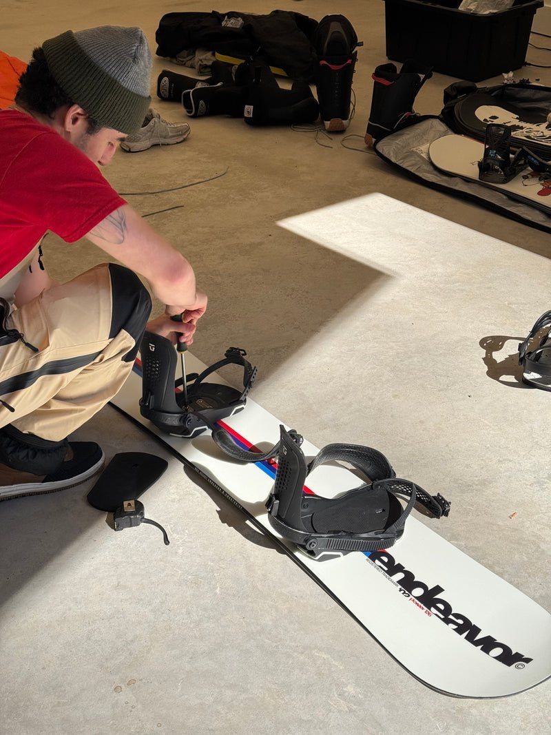 A fitter mounting bindings on a board