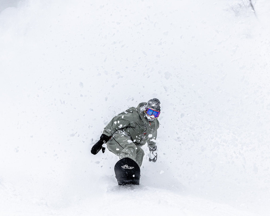 Snowboarder riding deep powder