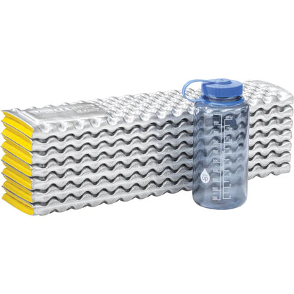 Stack of wavy metal sheets with a water bottle on a white background