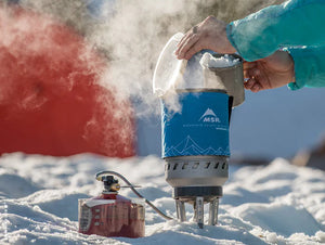 MSR WindBurner Duo System in use outdoors—steam rising from pot in snowy environment
