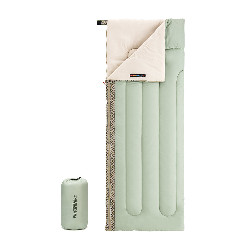 A light green rectangular sleeping bag with a beige interior visible at the top. The sleeping bag is shown alongside its carrying case.