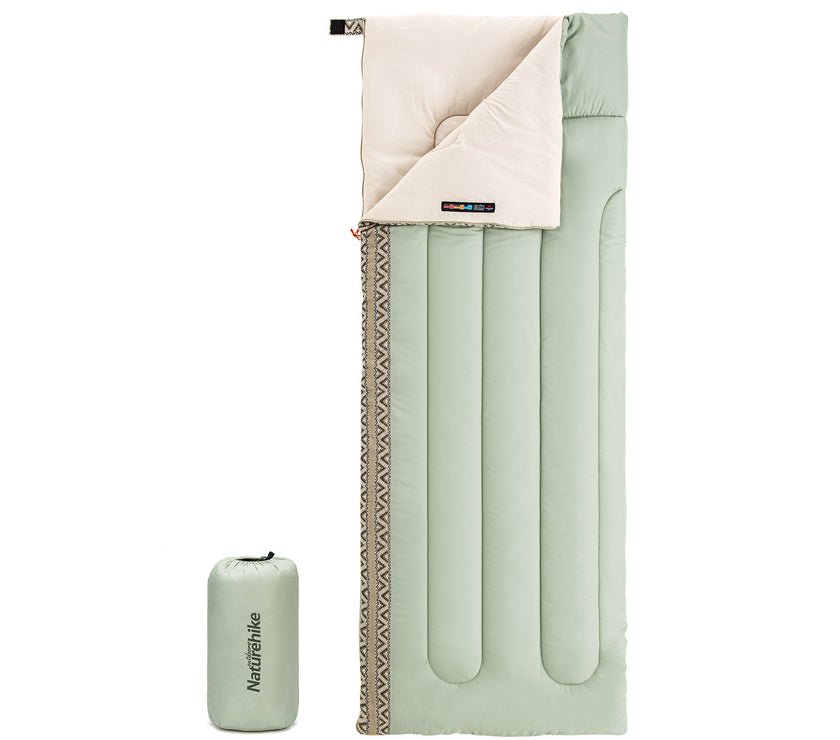 A light green rectangular sleeping bag with a beige interior visible at the top. The sleeping bag is shown alongside its carrying case.