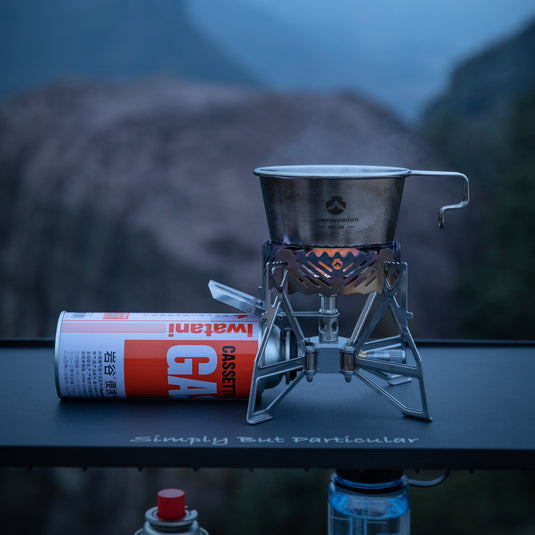 Campingmoon XD‑3 butane stove set up with pot on burner and canister attached, wilderness backdrop