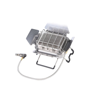 A silver portable camping stove with a foldable design and a gas connection hose.