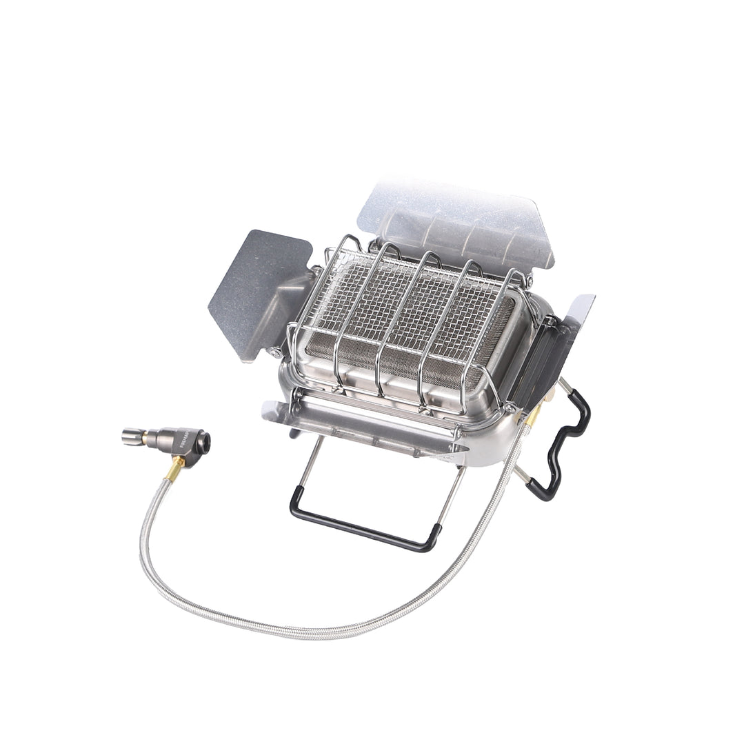 A silver portable camping stove with a foldable design and a gas connection hose.