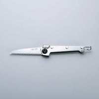 A folding saw with a stainless steel handle and a serrated blade, finished with Tsubamesanjo.