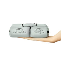 Naturehike inflatable sleeping pad held by a hand on a white background