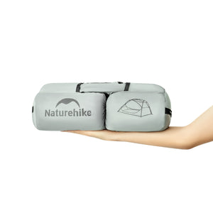 Naturehike inflatable sleeping pad held by a hand on a white background