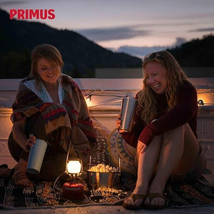 Campers gathered around Primus EasyLight lantern illuminating campsite at night