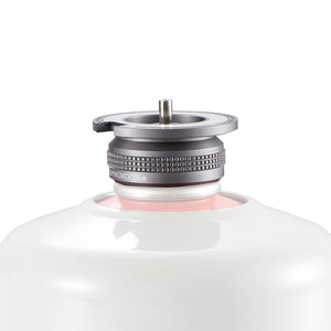 A close-up image of a silver butane stove adapter with a magnetic lock system, attached to a white cylindrical container.