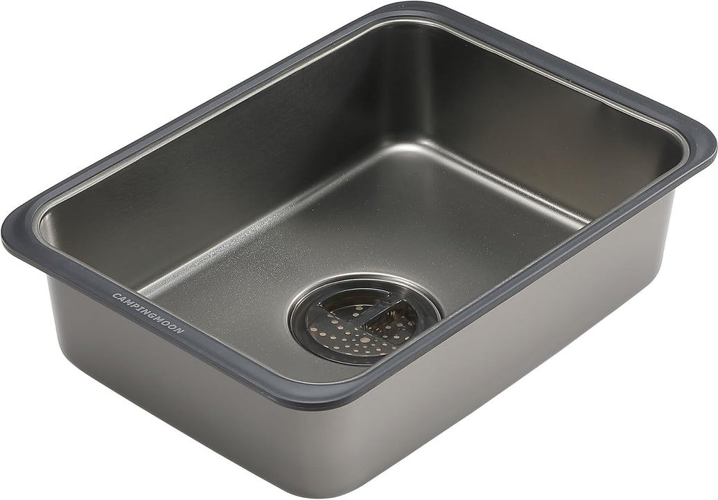 Stainless steel kitchen sink with drainboard on a white background