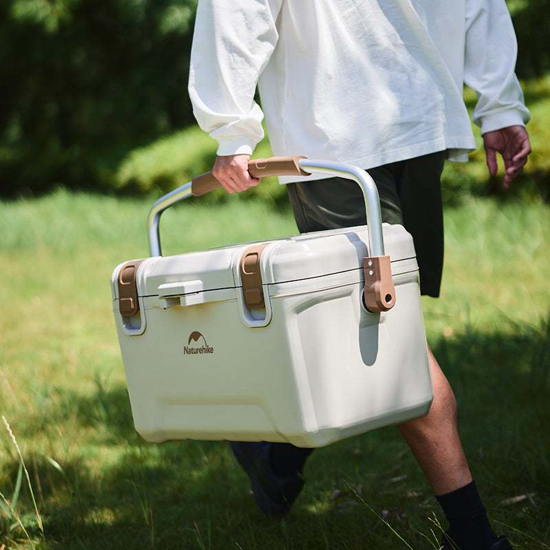 A guy holding the Naturehike Ling xia Cooler walking on the grass