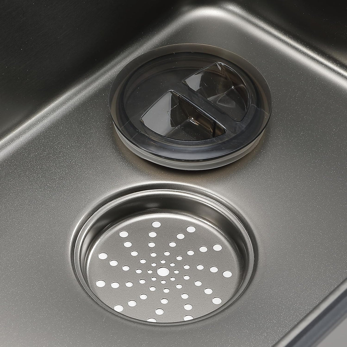Close-up of a kitchen sink drain with a strainer cover.