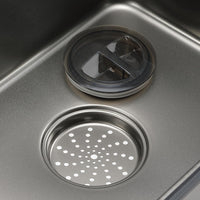 Close-up of a kitchen sink drain with a strainer cover.
