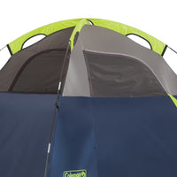 Coleman tent with green, gray, and blue sections on a white background