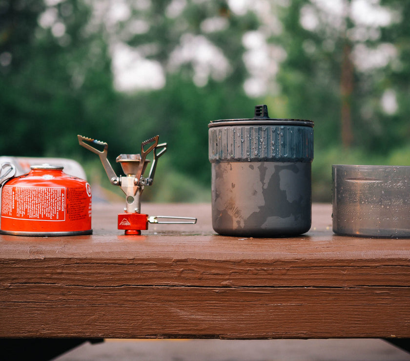 MSR PocketRocket 2 set up outdoors amid camping gear, ready to cook