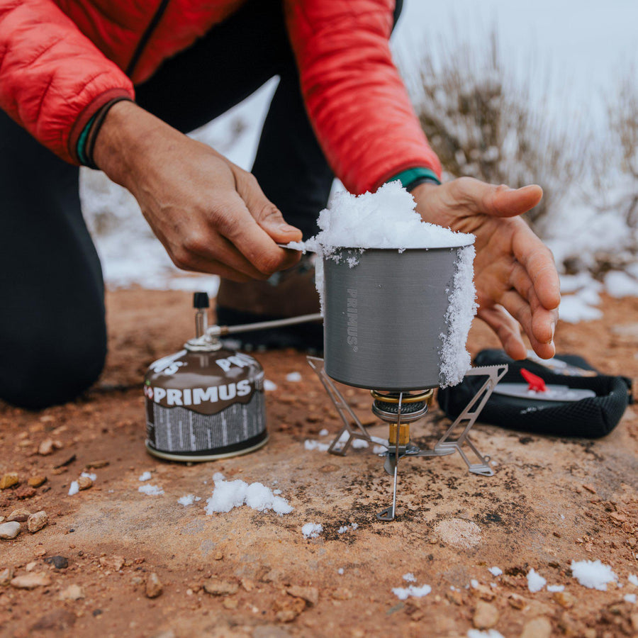 Primus Express Spider components laid out: stove, reflector plate, and carry bag on ground