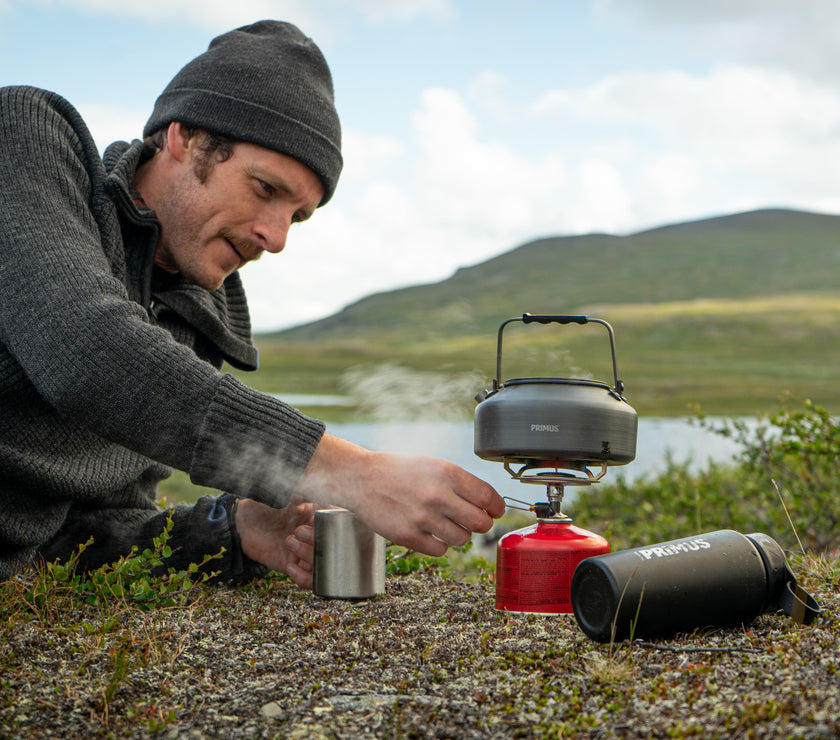Outdoor scene showing the kit boiling water on a small canister stove setup