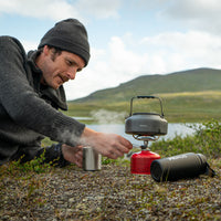 Outdoor scene showing the kit boiling water on a small canister stove setup