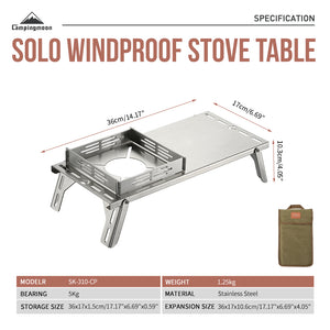 Dimensions labeled on the side of A silver stainless steel camping table with integrated windbreak and heat insulation, displayed alongside a carrying bag.