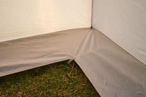 Close-up of a beige tent corner on grass