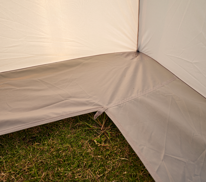Close-up of a beige tent corner on grass