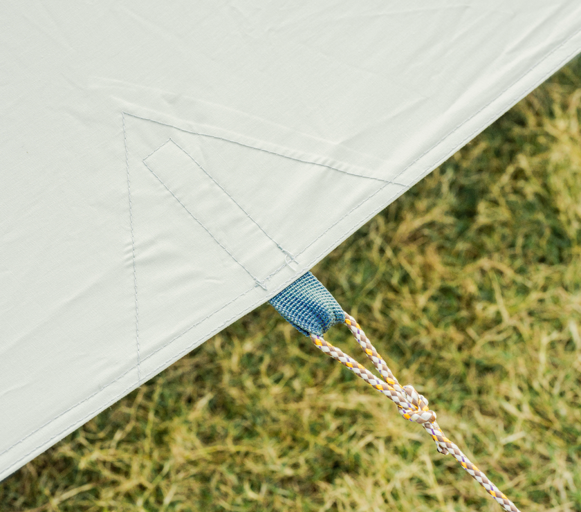 Close-up of a tent's corner with grass in the background