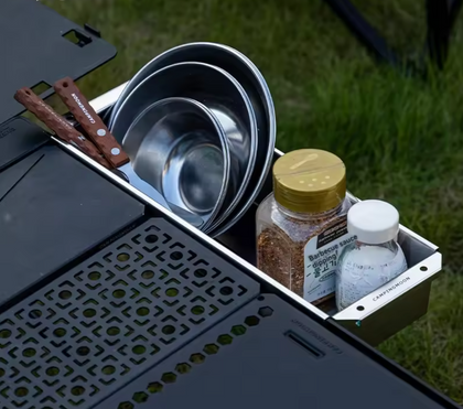 Cooking utensils and ingredients on a portable stove outdoors