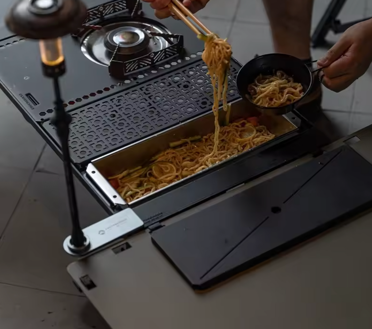 Portable stove with food being cooked on a tiled floor