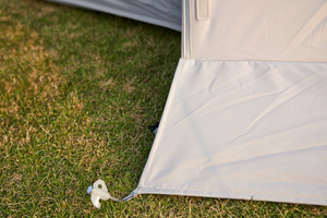 Close-up of a tent corner with grass in the background