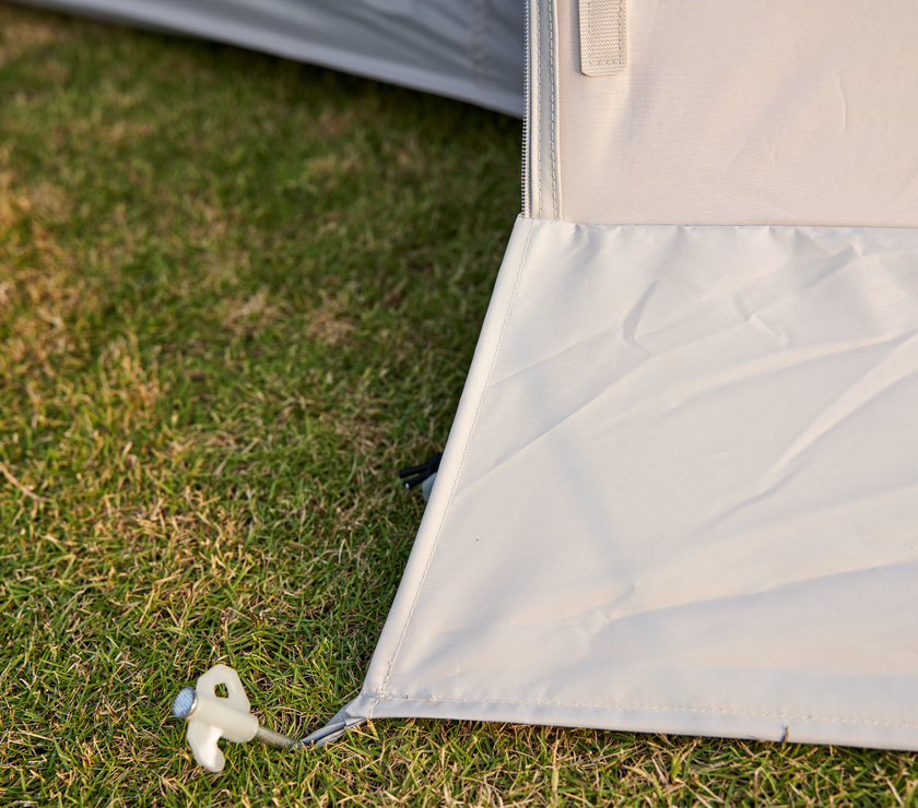 Close-up of a tent corner with grass in the background