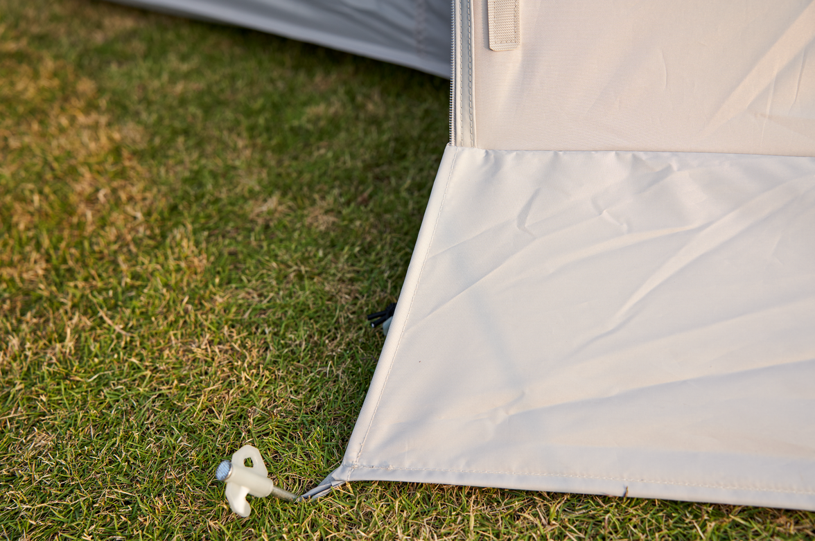 Close-up of a tent corner with grass in the background