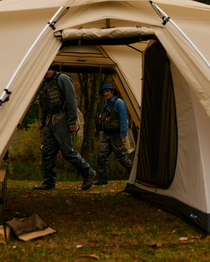 Snow Peak Land Nest Shelter TP-259 open at an autumn camp as two anglers in waders walk past