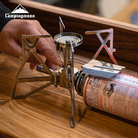 Campingmoon XD‑3 butane stove in action—blue flame burning from foldable burner in cozy indoor setting