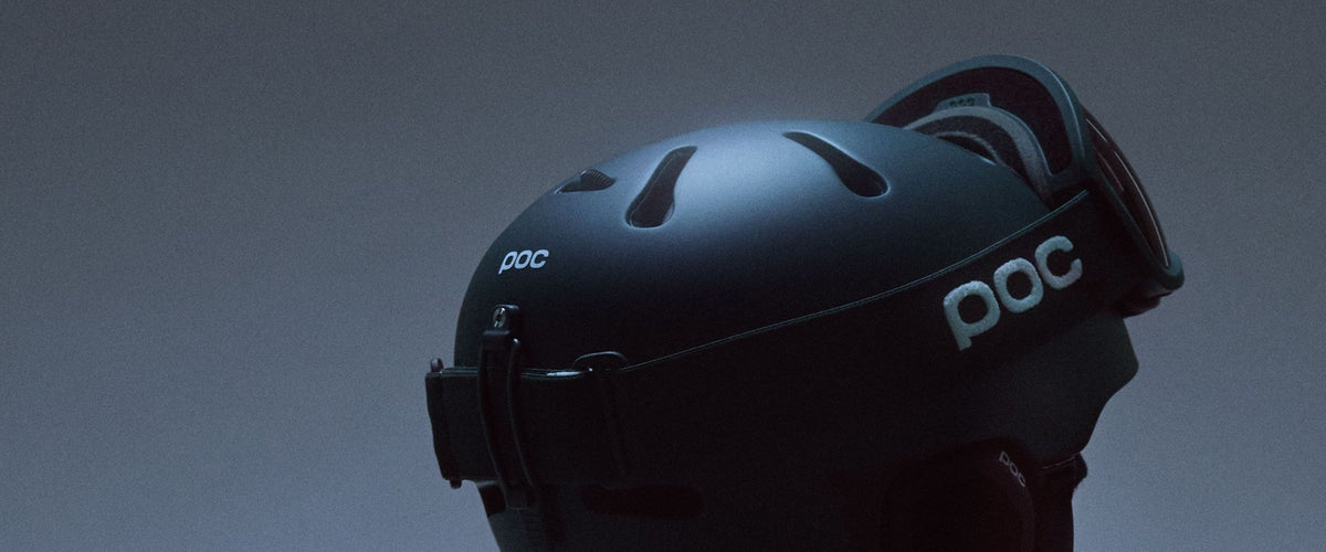 POC ski helmet with a goggle, side view on a blue-grey background