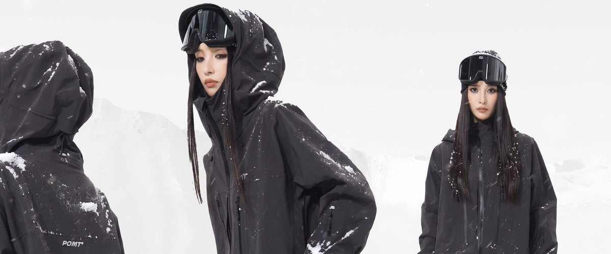 Three riders in black POMT Dermizax shells against a misty snowy mountain
