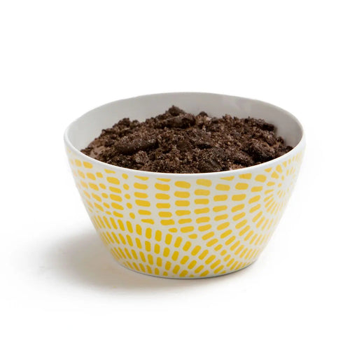 Prepared dark chocolate mousse topped with cookie crumb in a camp bowl