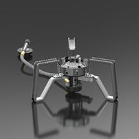 A silver portable gas stove with foldable stand and advanced wind-resistant technology, isolated on a grey background.