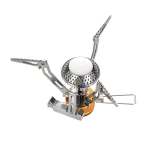 A compact and portable Fire Maple FMS-102 camping stove with an integrated ignition system, featuring silver and gold colors with a foldable design and serrated foot.