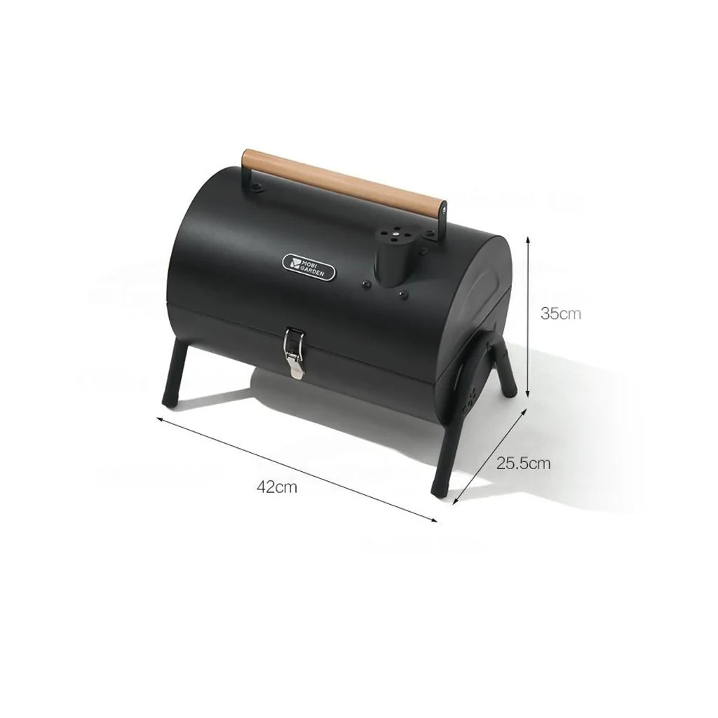 Dimensions labeled on the side of A compact, black two-sided barbecue stove with a wooden handle, designed for outdoor cooking activities like camping and picnics.