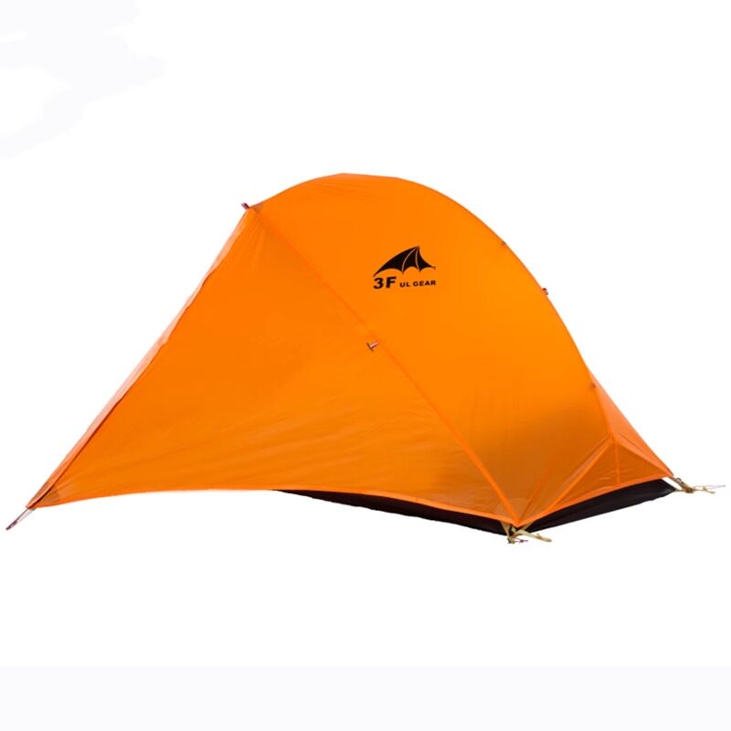 Side view of the pitched orange tent showing the vestibule and low-profile ridge