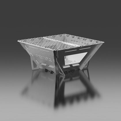 A stainless steel Fire Maple Maverick Wood Stove with four panels, featuring a foldable grill and a dark reflective background.