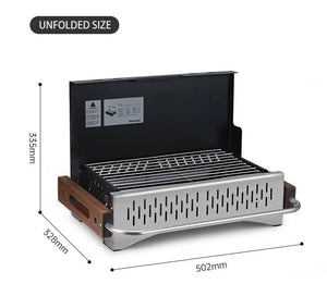 Dimensions labeled on the side of A foldable black tabletop travel BBQ grill with wooden handles and a detachable baking net.