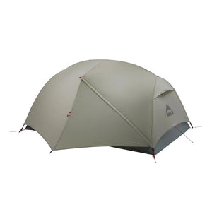 A green MSR Hubba Hubba LT 2P Tent pitched, showing the exterior body without the fly.