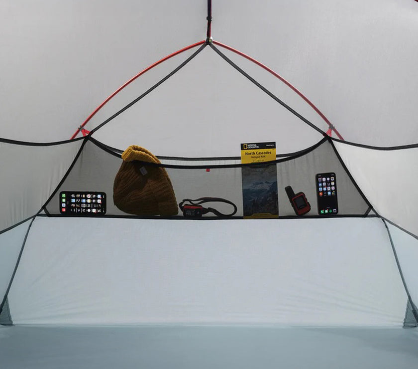 Inside of a tent with various items on a shelf