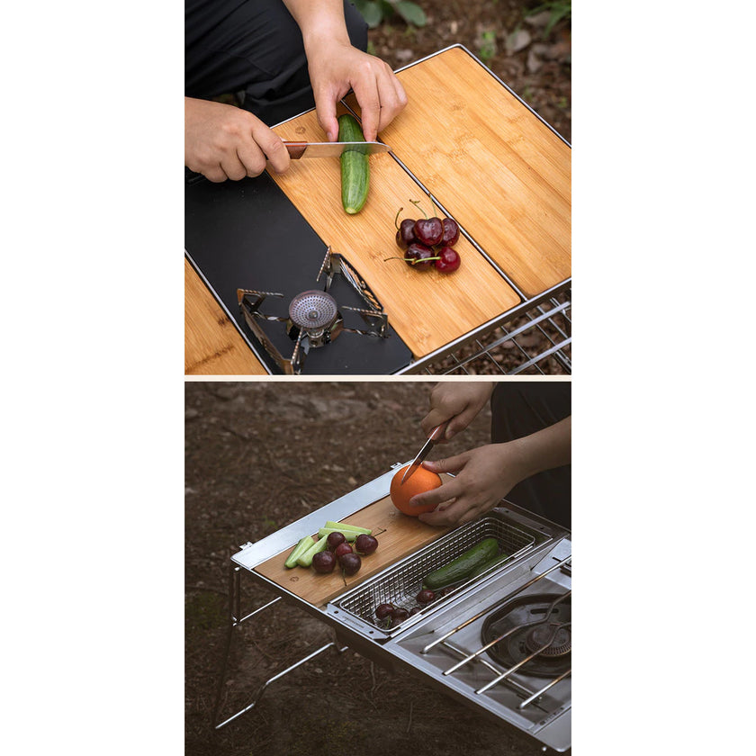 Person cutting vegetables on a portable outdoor cooking setup with a stove and grill.